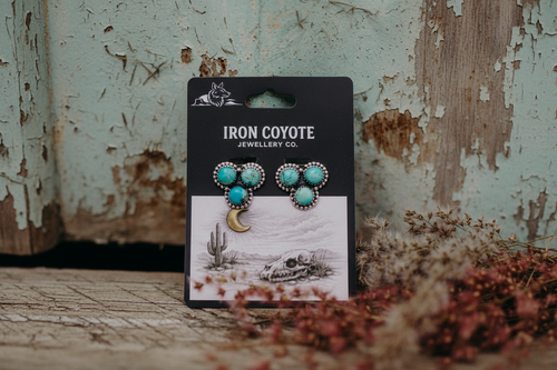 Turquoise earrings on a 'Iron Coyote Jewellery Co.' card with a rustic background
